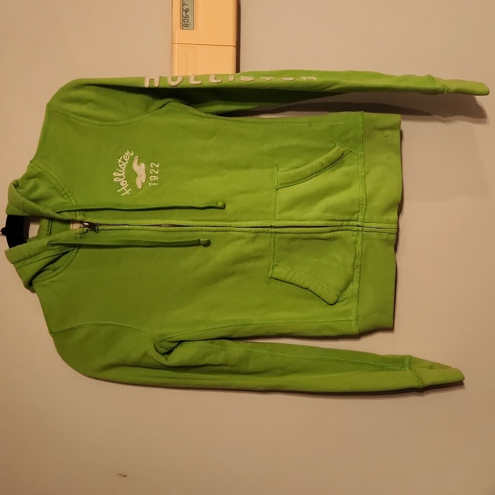 Small neon green Hollistet zip up hoodie with logo sewn on left arm
